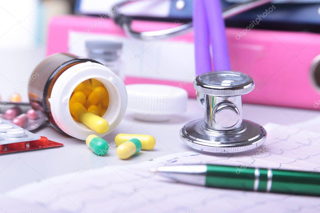 Close-up stethoscope lying on RX prescription with assorted pills. Healthy life or insurance concept.