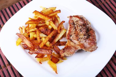 Ekmek arası sığır eti biftek patates ücretsiz, taze domates ve kahverengi taş zemin üzerine sos ızgara