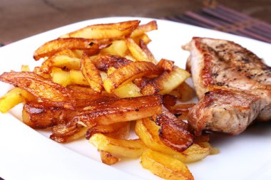 Ekmek arası sığır eti biftek patates ücretsiz, taze domates ve kahverengi taş zemin üzerine sos ızgara