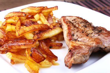 Ekmek arası sığır eti biftek patates ücretsiz, taze domates ve kahverengi taş zemin üzerine sos ızgara