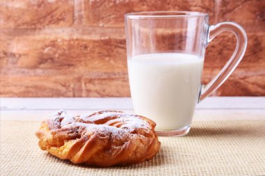 Çikolata ve pudra şekeri krem puf yüzük ve ahşap masa üzerinde süt ile cam. geleneksel kahvaltı.