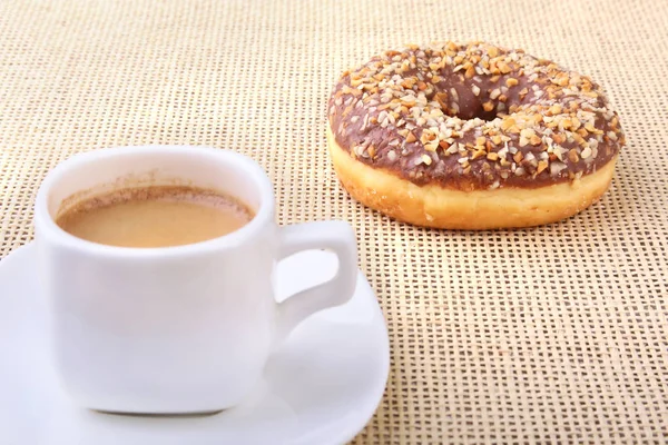 Перерыв на кофе со свежими пончиками на текстильном фоне . — стоковое фото