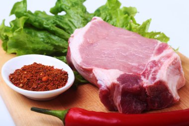 Çiğ Domuz pirzola otlar ile ve kesme tahtası üzerinde baharat. Hazır yemek pişirmek için.