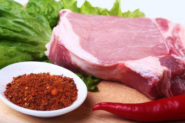 Çiğ Domuz pirzola otlar ile ve kesme tahtası üzerinde baharat. Hazır yemek pişirmek için.