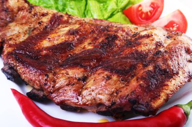 Domuz kaburga Barbekü ve biber domates ile beyaz tabağına marul yaprakları