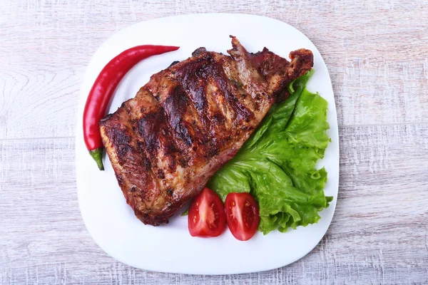 Rusuk babi pada barbeque dan cabai dengan tomat, daun selada di piring putih — Stok Foto