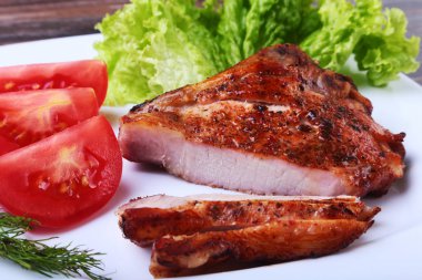 ızgara domuz pirzola ile domates, marul ve ketçap plaka üzerinde bırakır.