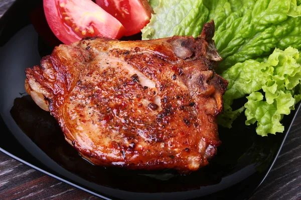 Daging babi panggang dengan tomat, daun selada dan saus tomat di atas piring . — Stok Foto