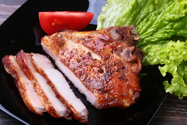 Daging babi panggang dengan tomat, daun selada dan saus tomat di atas piring . — Stok Foto