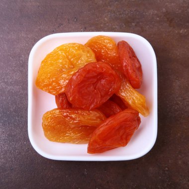 Taş masaya izole kase lezzetli kuru organik kayısı.