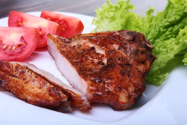 Daging babi panggang dengan tomat, daun selada dan saus tomat di atas piring . — Stok Foto