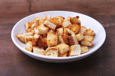 Lezzetli çıtır kruton, beyaz tabak içinde ekmek kırıntıları. hazır yemek pişirmek için.