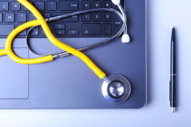İşyeri dizüstü bilgisayar, stetoskop ve Rx reçeteli beyaz masada doktor. Üstten Görünüm.