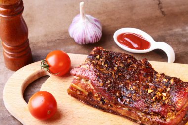 Koyu arka plan üzerinde kesme tahtası üzerinde ızgara domuz pirzola Barbekü chimichurri sos ve domates Striploin biftek dilimlenmiş.