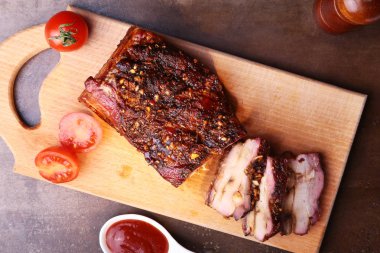 Koyu arka plan üzerinde kesme tahtası üzerinde ızgara domuz pirzola Barbekü chimichurri sos ve domates Striploin biftek dilimlenmiş. Üstten Görünüm.