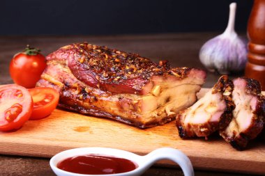 Koyu arka plan üzerinde kesme tahtası üzerinde ızgara domuz pirzola Barbekü chimichurri sos ve domates Striploin biftek dilimlenmiş.