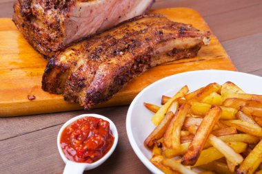 Beyaz plaka üzerinde patates ücretsiz ve sos ile ızgara domuz kaburga.