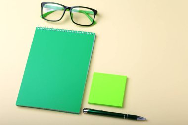 İş amaçlı aksesuarları üstünde okul sırası: Not Defteri, günlük, dolma kalem, gözlük. Makro bulanıklık ve yumuşak odak ile.