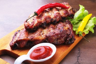 marul yaprakları, sıcak biber ve sos ahşap kesme tahtası üzerinde mangalda kaburga ızgara.