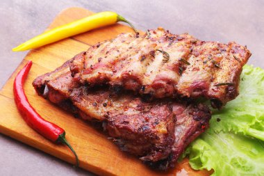 marul yaprakları, sıcak biber ve sos ahşap kesme tahtası üzerinde mangalda kaburga ızgara.