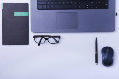 Rahat çalışma close-up yerleştirin ofis dizüstü bilgisayar, fare, defter, gözlük, kalem ve tablo kopya alanı ile döşeme diğer ekipmanlar. Üstten Görünüm.