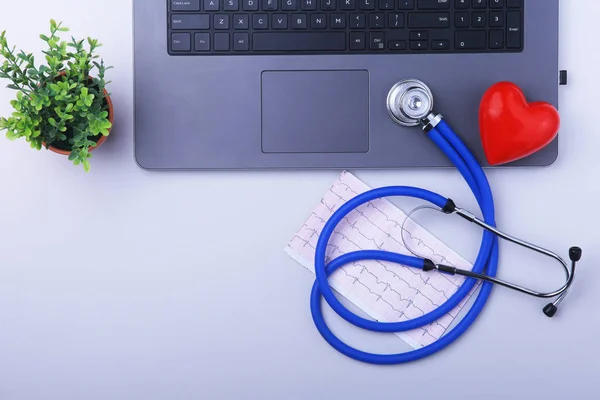 Arbetsplatsen som läkare med laptop, stetoskop, Rx recept, Glasögon och röda hjärtat och anteckningsbok på vitt bord. ovanifrån. Kopiera utrymme. — Stockfoto