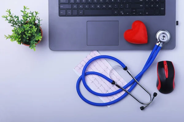 Arbetsplatsen som läkare med laptop, stetoskop, Rx recept, Glasögon och röda hjärtat och anteckningsbok på vitt bord. ovanifrån. Kopiera utrymme. — Stockfoto