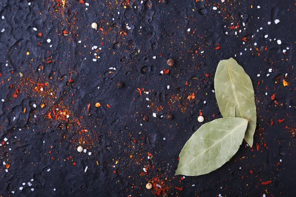 Red spices, salt and pepper on black marble. Black abstract background. Top view.