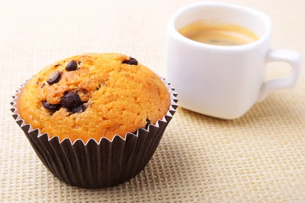 Perfekt morgon frukost med läckra hembakade muffins med russin, choklad, chips och espressokaffe i vit kopp på textil bakgrund. Muffins. — Stockfoto