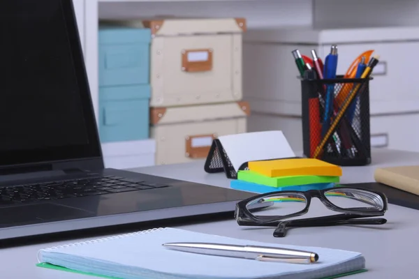 ノート パソコン、マウス、ノート、メガネ、ペンと他の機器をテーブルに置くとオフィスで快適な職場のクローズ アップは、家具の背景をぼかし. — ストック写真
