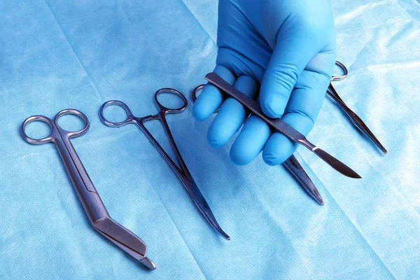 Prise de vue détaillée d'instruments chirurgicaux stérilisés avec une main saisissant un outil  , — Photo