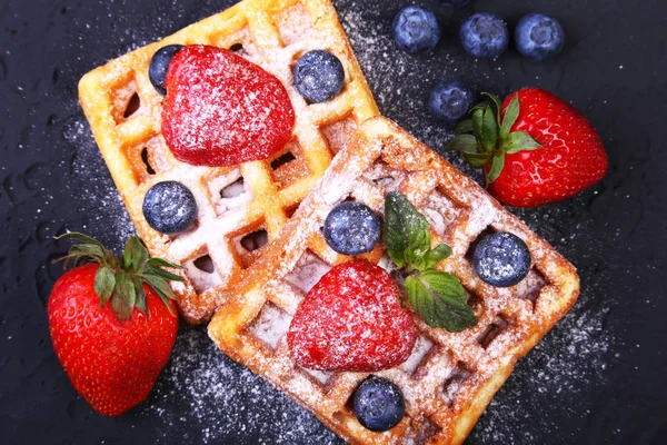 Waffles belgas tradicionais caseiros com frutas frescas, bagas e açúcar em pó no prato preto. Flat lay, vista superior, espaço de cópia . — Fotografia de Stock