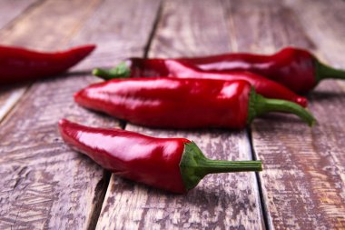 Ahşap arka planda taze kırmızı kırmızı kırmızı kırmızı biber.
