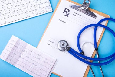 Kardiyogram çizelgesinde tıbbi steteskop var. Tıbbi yardım, prezervatif, hastalık önleme ya da sigorta konsepti. Kardiyoloji bakımı. Üst Görünüm.