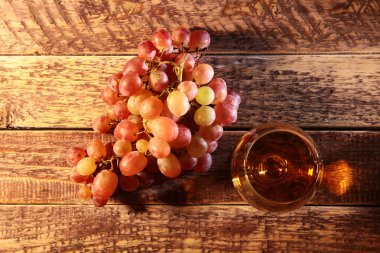 Konyak ya da brendi cam ve taze üzüm, natürmort rustik tarzı, vintage ahşap arka plan, seçici odak.