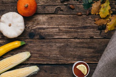 Sonbahar sebze: çay, kabak ve Mısır ile sarı yaprakları bir ahşap arka plan üstten görünüm