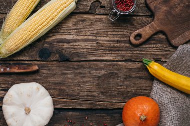 Sonbahar sebze: kabaklar ve sarı yaprakları ve mutfak ahşap bir zemin üzerine kurulu kesilmiş Mısır ile