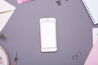 Beyaz not defterli cep telefonu, pembe defter ve gri arka plan görünümlü nakış.