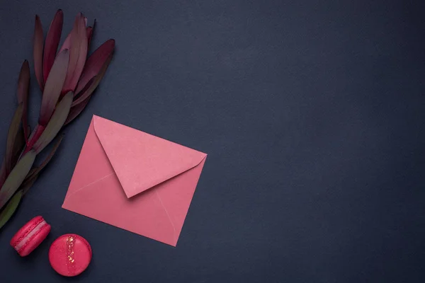 Dark wallpaper with gift envelope and flower top view