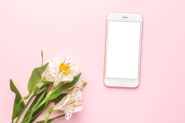 Cep telefonu ve beyaz çiçek Alstroemeria pembe arka plan görünümlü