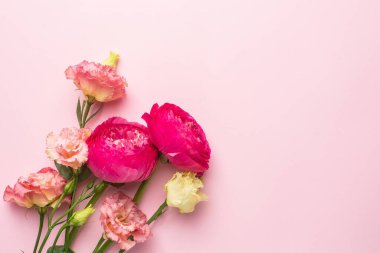 Pastel arka planda, telif alanı üst görüşlü pembe ve beyaz çiçek buketi.