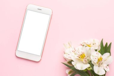 Cep telefonu ve beyaz çiçek Alstroemeria pembe arka plan görünümlü