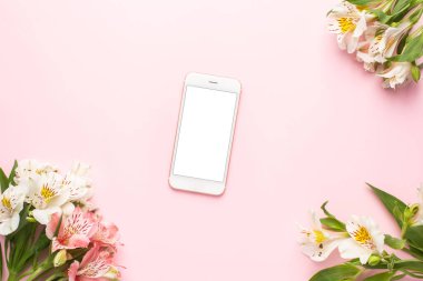 Cep telefonu ve beyaz çiçekler Pembe arka plan görünümlü Alstroemeria