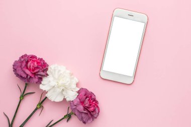 Pembe arka planda mor ve beyaz karanfil çiçekli cep telefonu.