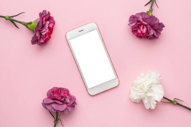 Pembe arka planda mor ve beyaz karanfil çiçekli cep telefonu.