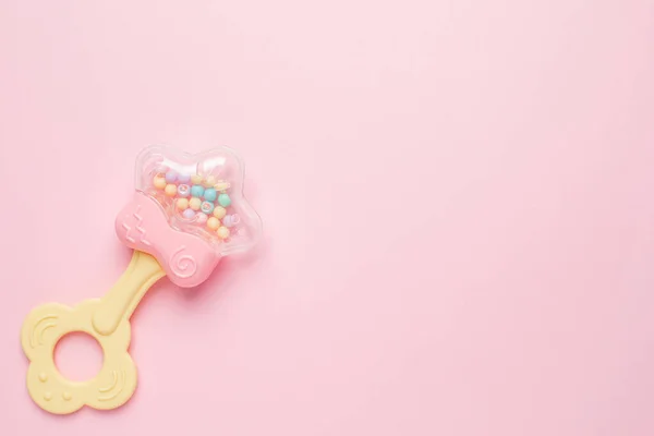 Güzel bebek çıngırağı. Pembe arka planda ip var. Telif alanı üst görünümü var.