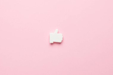 Beyaz el, pembe arkaplan görünümünde minimal bir şekilde sembol gibi