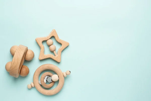 Tahta bebek oyuncağı açık mavi arka planda çıngırak, doğal ekolojik malzemeler ve erken bebek gelişimi üst görünümü