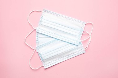 Pembe arka planda tıbbi maskeler, salgın ikinci dalga ve covid enfeksiyondan korunma