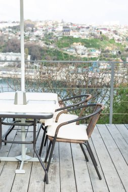 Şehir manzarasına bakan bir kafede masalı sandalyeler.